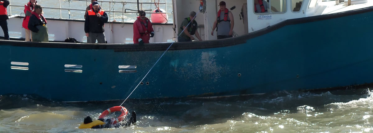 Nova Scotia fishermen undergoing safety training: assisting an overboard fisherman get back into the boat.